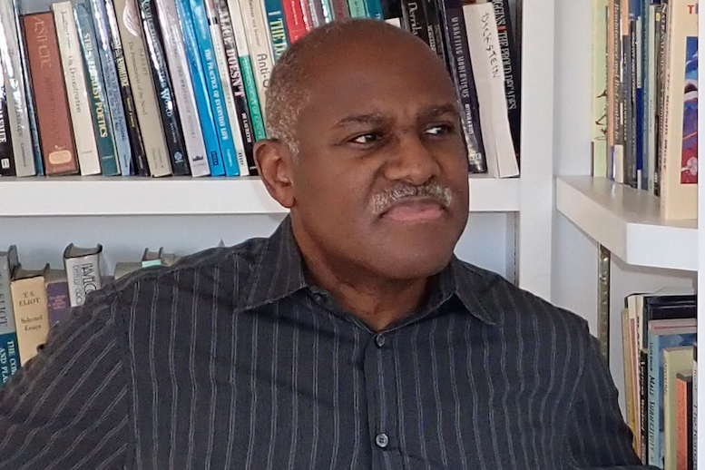 Marlon Ross Headshot, African American man against book case